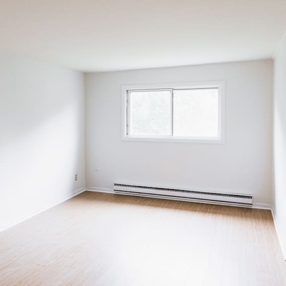 a room with a window and a radiator on the floor.