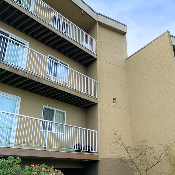 a building with beige walls and white railings.