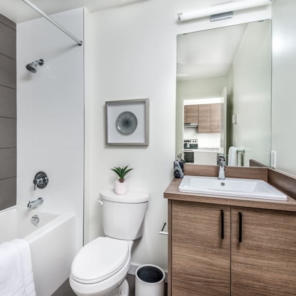 a bathroom with a toilet, sink, and mirror.