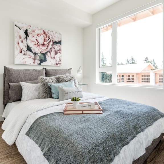 a bedroom with a large bed and a floral painting on the wall.