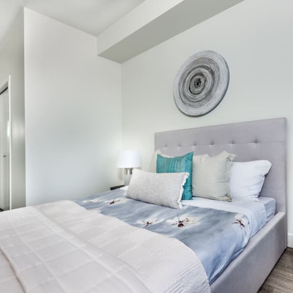 a bedroom with a large bed and a round decorative piece on the wall.