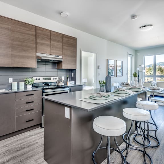 a modern kitchen with a large island and bar stools.