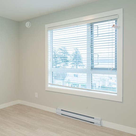 a room with a window showing a view of a residential area.