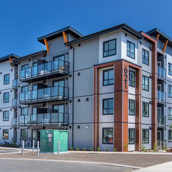 a modern apartment building with a mix of grey, brown, and blue tones.