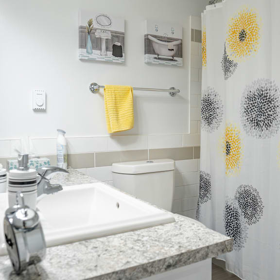 a bathroom with a sink, toilet, and shower curtain.