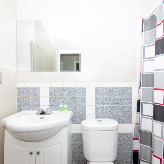 a white sink and toilet in a bathroom with a mirror above it.