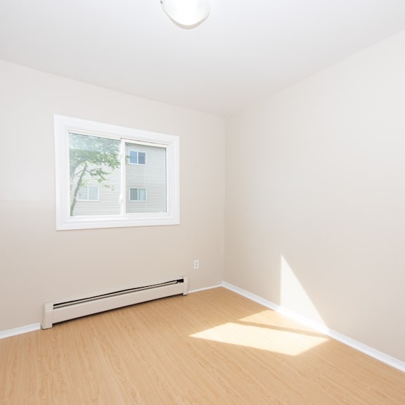 a room with a window and a radiator on the wall.