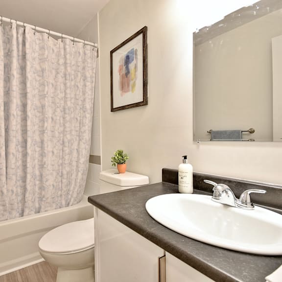 a bathroom with a toilet, sink, and shower curtain.