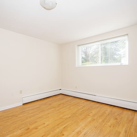 empty room with wooden floor and white walls.
