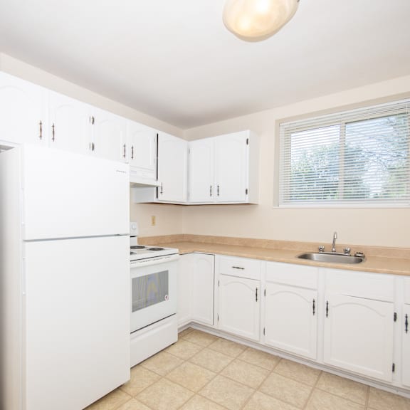 a kitchen with white cabinets and appliances.