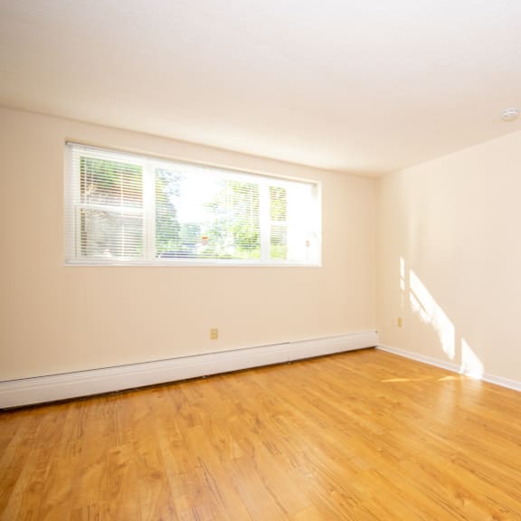 a room with a window and wooden floors.