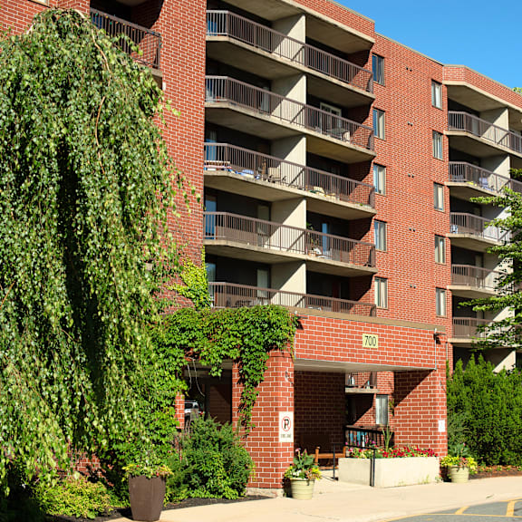 a red brick building with balconies and a parking sign.
