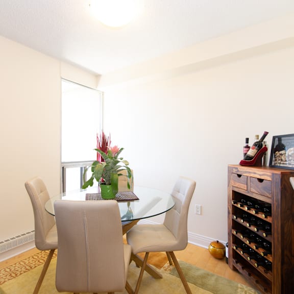a dining room with a glass table and chairs.