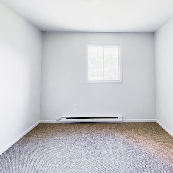 a room with a window and a radiator on the floor.