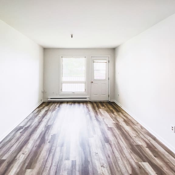 a room with a wooden floor and white walls.