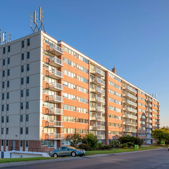 a large apartment building with a car parked in front.