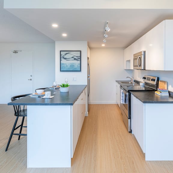 a kitchen with white cabinets and a black countertop.
