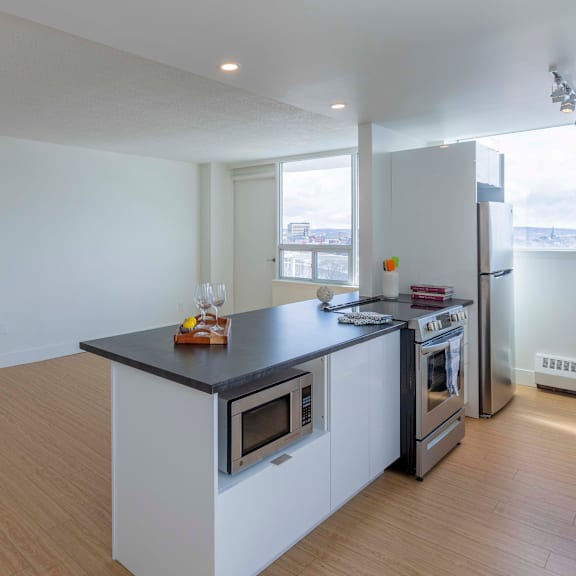 a kitchen with a black countertop and white cabinets.