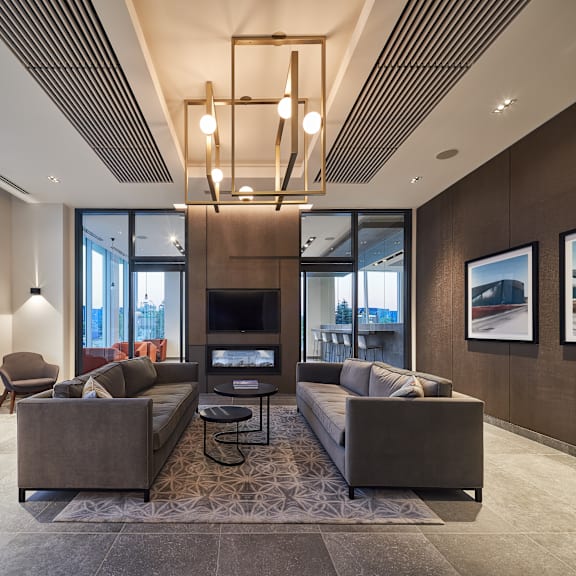 a modern living room with a brown sofa set and a large window.