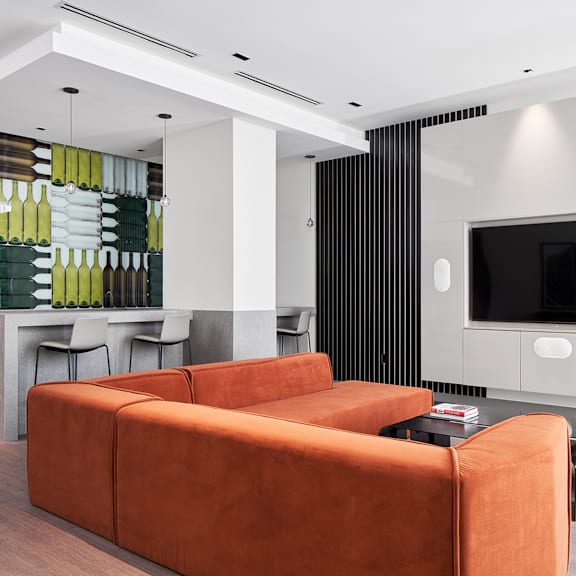 a modern living room with a brown sofa and a black television.