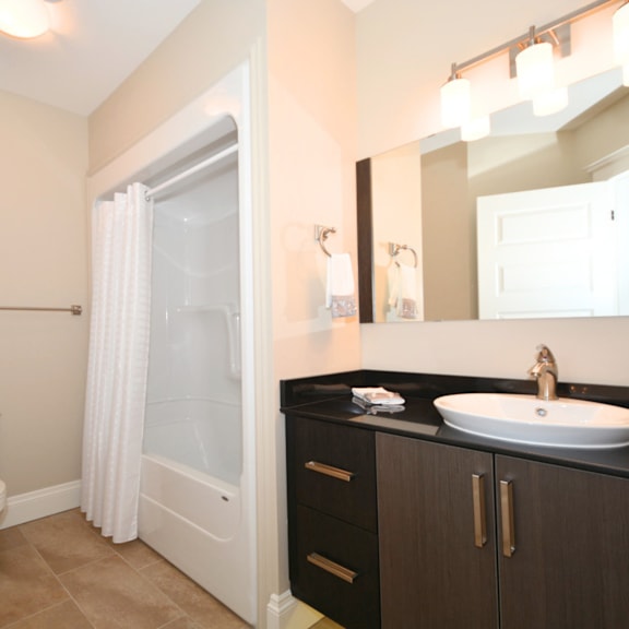 a bathroom with a toilet, sink, and shower.