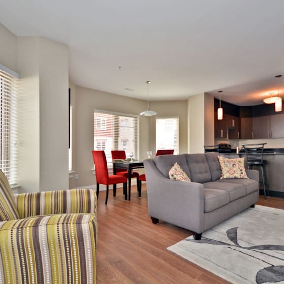 a living room with a grey couch and a striped armchair.