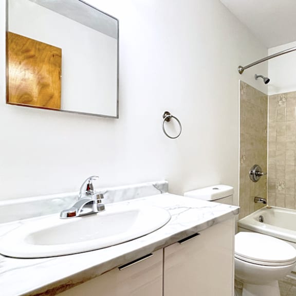 a bathroom with a sink, toilet, and tub.