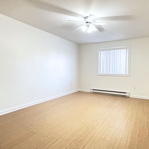 a room with a ceiling fan and a window with blinds.