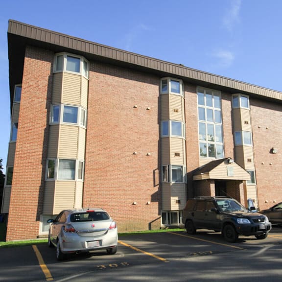 a car is parked in front of a brick building.