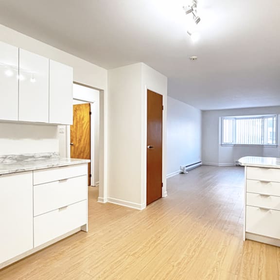 a kitchen with white cabinets and a wooden door.