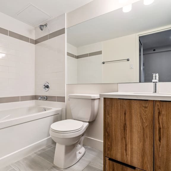 a white toilet sits next to a bathtub in a bathroom.