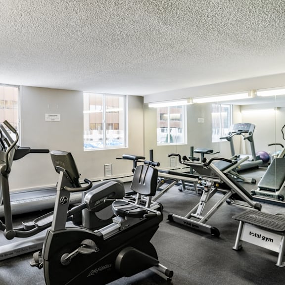 a gym with treadmills, elliptical machines, and other exercise equipment.