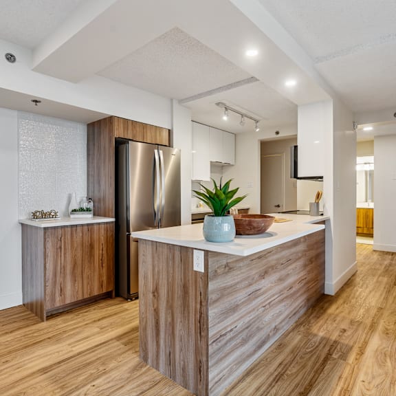 a modern kitchen with wooden cabinets and a stainless steel refrigerator.