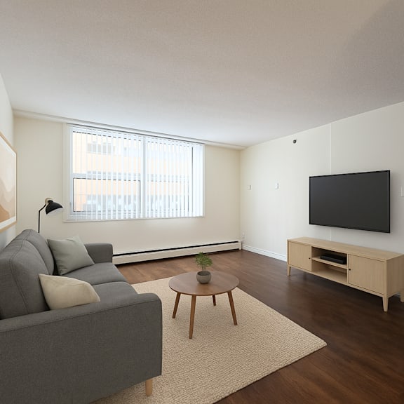 a living room with a grey couch, a wooden coffee table, and a flat screen tv mounted on the wall.