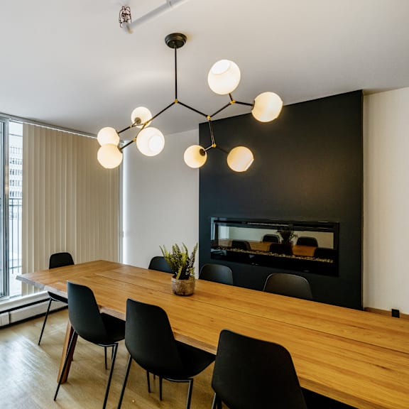 a modern dining room with a wooden table and black chairs.