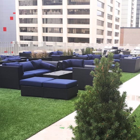 a large outdoor seating area with blue couches and a white pathway.