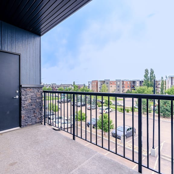 a black door is on a stone wall.