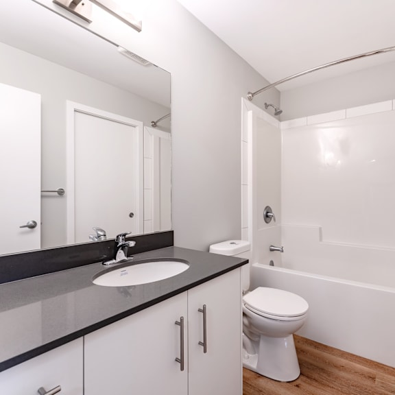 a white toilet sits in a bathroom with a sink and mirror.