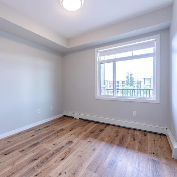 a room with a window and wooden flooring.