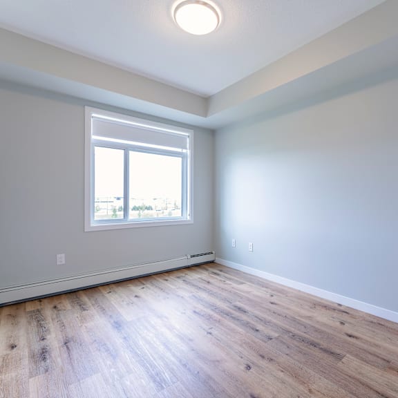 a room with a window and wooden flooring.