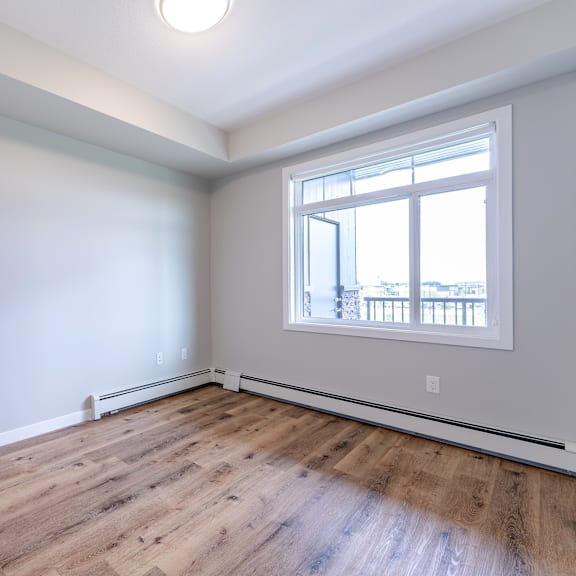 a room with a large window and wooden flooring.
