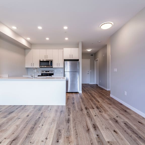 a kitchen with wooden floors and white walls.