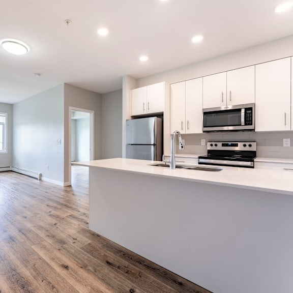 a kitchen with a refrigerator, microwave, and oven.