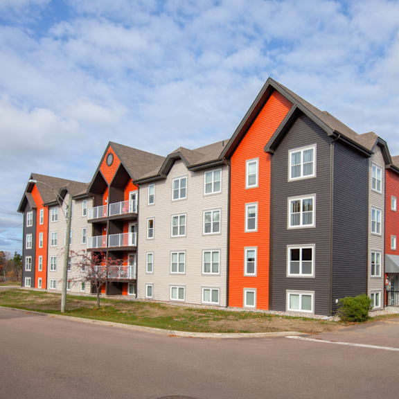a large apartment building with grey and orange accents.