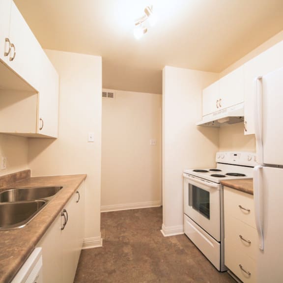 a kitchen with white appliances and a brown counter top.