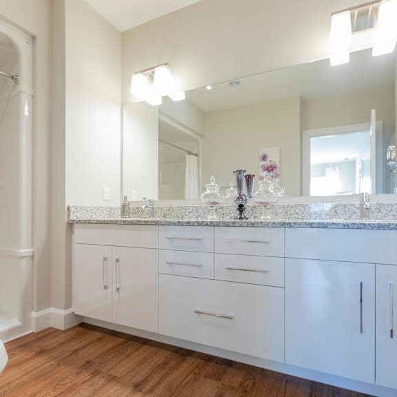a bathroom with a white toilet, a marble countertop, and a large mirror.