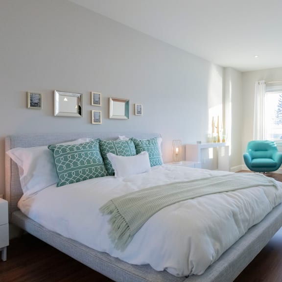 a bedroom with a large bed and a blue chair.