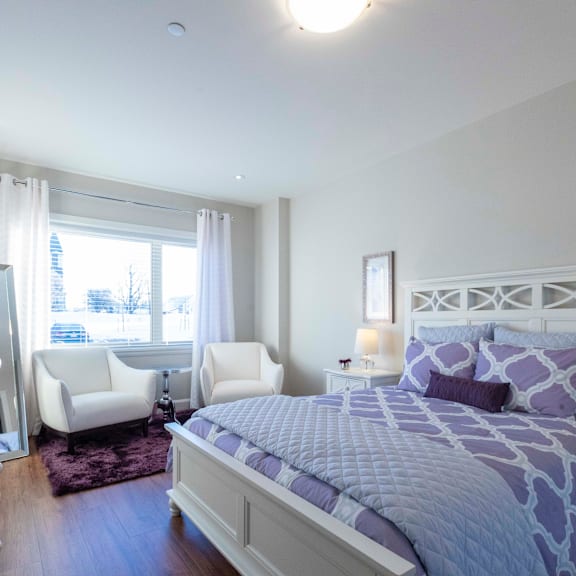 a bedroom with a large bed and two chairs.