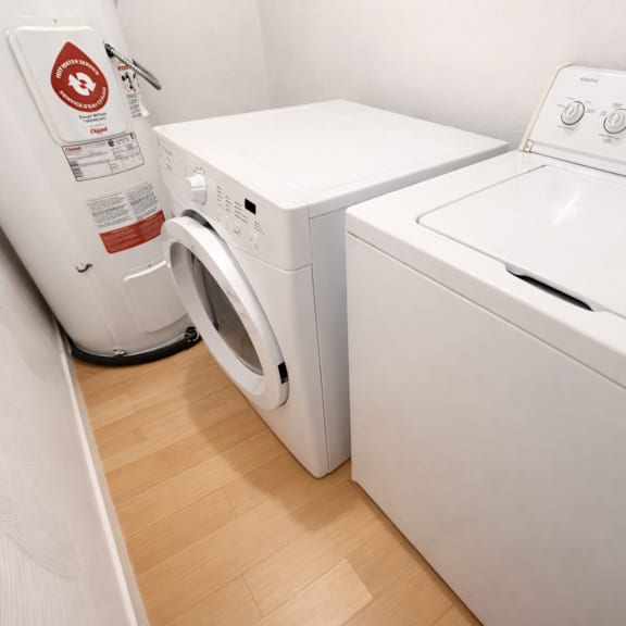 a white washing machine and dryer in a small laundry room.
