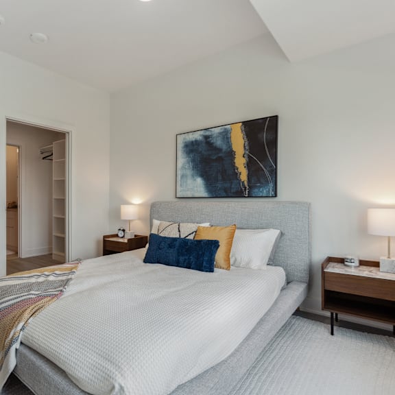 a bedroom with a large bed and a painting on the wall.